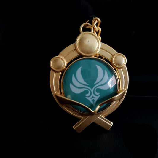 Genshin Impact Inazuma Vision Keychain: gold, teal stylized winged or floral emblem, ornamental fantasy-inspired style